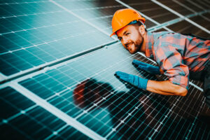 male worker cleaning solar panels